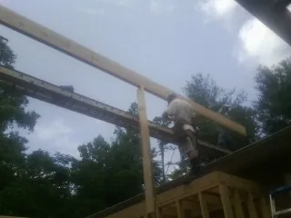 Carpenter setting a ridge beam over a new addition frame — Ice Dam Removal by Roofing Brothers in Henrico