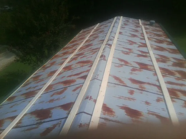 Rusted metal roof panels with new wood purlins before replacement — Storm Damage Roof Repair in Henrico by Roofing Brothers