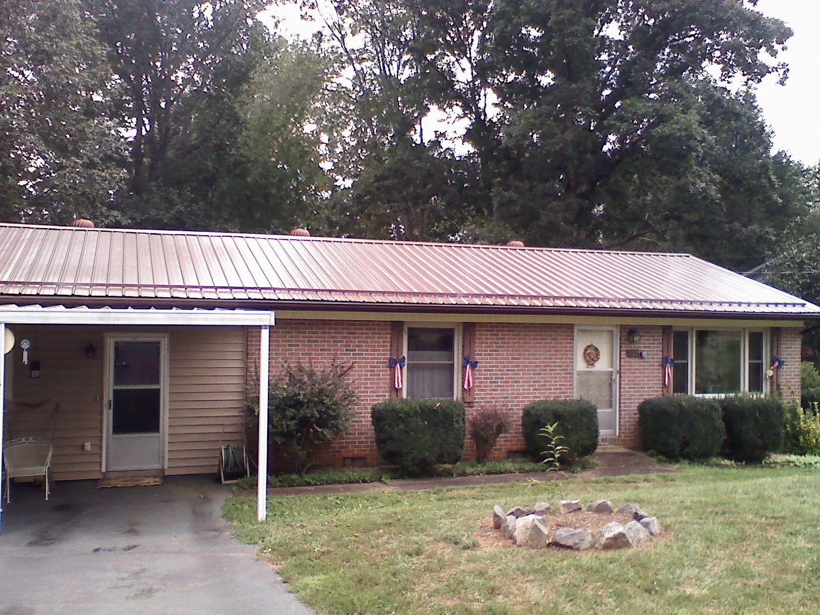 Bronze metal roof and carport on a brick ranch home — Roof Repair work by our crew in Henrico