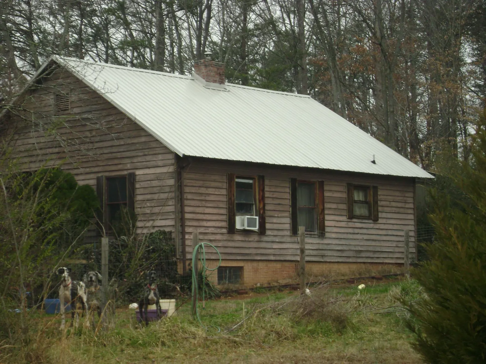 White metal roof on an old wood sided farmhouse, from a Metal Roof Installation job in Henrico